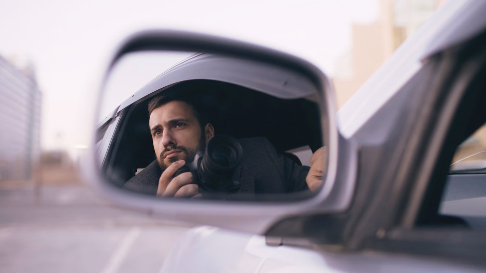 Man looking in car side mirror